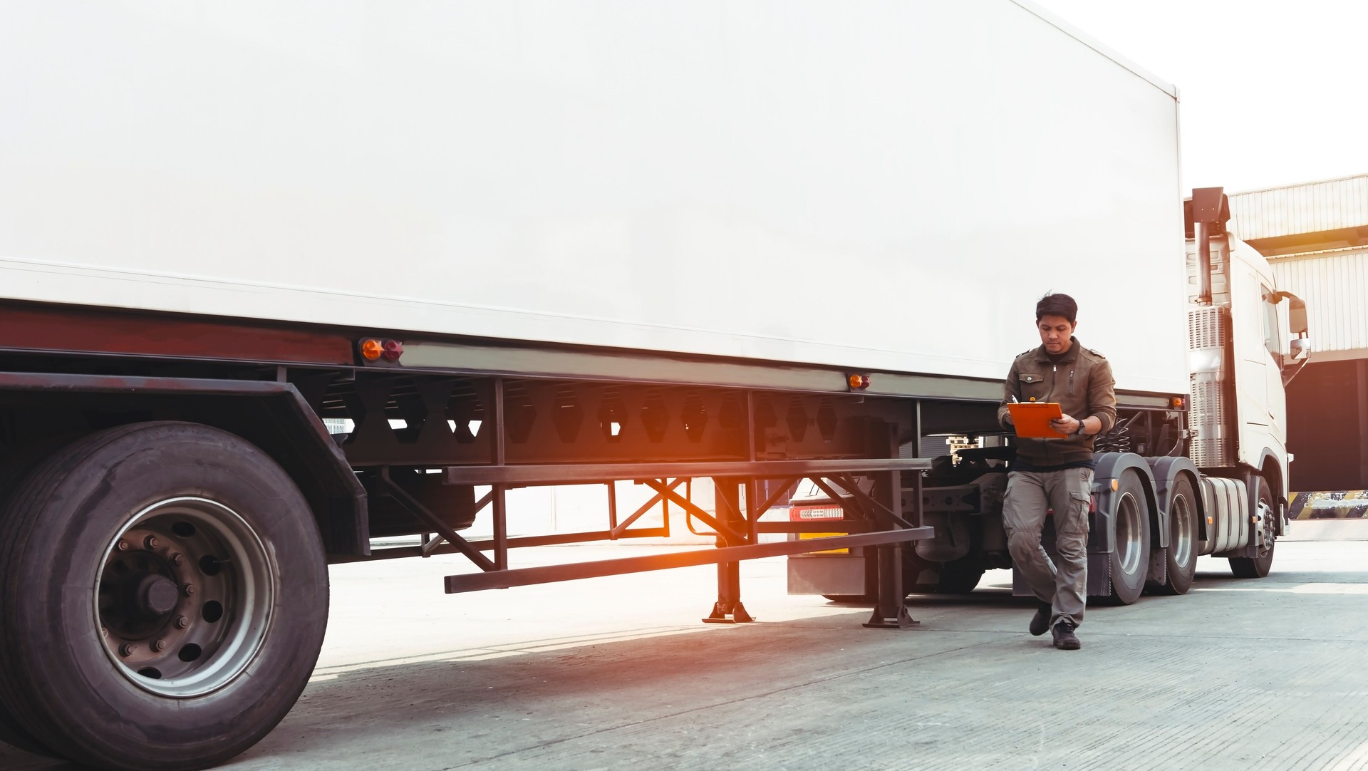 Asian truck driver holding clipboard inspecting safety a truck
